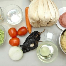 Ingredientes para receta 1 kilogramo de masa de maíz hojas de maíz secas (totomoxtle) al gusto aceite vegetal comestible al gusto 1/2 pieza de cebolla blanca 1 diente de ajo 3 piezas de chile mulato 3 piezas de jitomate guaje 1 pieza de zanahoria 1 taza de chícharos frescos 500 gramos de carne molida de puerco 250 gramos de manteca de puerco sal al gusto agua tibia al gusto