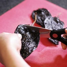 Para preparar el relleno, cortar e rabo de los chiles mulatos con una tijera. Abrir por un lado y retirar las semillas y las venas.