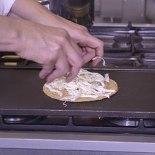 Añadir la mitad del queso desmenuzado.