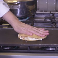 Continuar cociendo un minuto y voltear la tortilla. Cocer hasta que se derrita el queso y voltear una vez más.