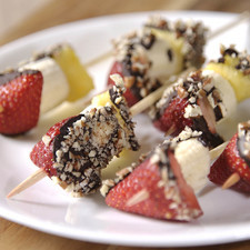 Pasar la fruta por el chocolate, después por la nuez y acomodar en una charola para galletas con papel encerado.