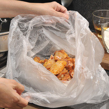 Colocar harina en una bolsa de plástico, introducir las alitas, cerrar la bolsa y agitar para que se impregnen de harina.