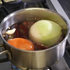 Poner a hervir las pieles de los chiles junto con el jitomate guaje, ajo y cebolla durante 5 minutos. Dejar enfriar