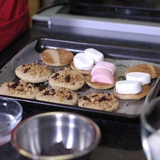Precalentar el horno a 350°F(180° C) durante 10 minutos, hornear a la misma temperatura durante 12 o 14 minutos. Retirar del horno y dejar enfriar.Colocar un malvavisco sobre cada galleta y hornear 4 minutos, cuando empiece a dorar el malvavisco, sacar del horno.
