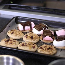 Colocar sobre él un trozo de chocolate y otra galleta encima para formar un sándwich.Presionar con la ayuda de la pala el sándwich y volver a hornear durante 3 minutos más.