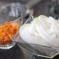 Cortar la cebolla en rodajas y picar finamente la zanahoria, reservar.