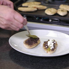 Para servir colocar los tlacoyitos en el plato, agregar un poco de los frijoles refritos, salsa y queso.
