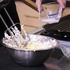 En un tazón batir el queso con el azúcar glass, la leche y la esencia de vainilla hasta suavizar.