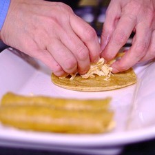 Rellenar cada tortilla con un poco de pollo deshebrado y colocar en un platón hasta terminar de rellenar todas.