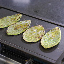 Calentar la parrilla y cuando esté bien caliente colocar las pencas de nopal y dejar asar unos minutos por cada lado.