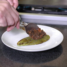 Para servir colocar la penca de nopal asada en el plato, añadir un poco de la mezcla de frijoles con chorizo.