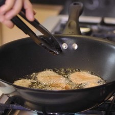 Calentar el aceite en una olla onda y cuando esté bien caliente agregar un puño de las rodajas de papa, moviendo constantemente para que no se peguen, hasta que estén doradas.