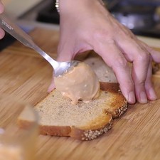 Tostar las rebanadas de pan hasta que queden dorados ligeramente. Colocar una rebanada de pan y untar un poco de la mezcla de mayonesa con cátsup.