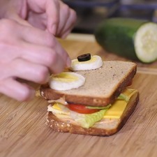Para decorar el sándwich y darle la figura de búho colocar dos rebanadas de huevo cocido y encima una rebanada de aceituna negra para formar los ojos.