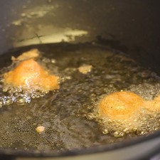 Calentar el aceite en una olla honda hasta que esté bien caliente y sofreír las bolitas moviendo constantemente hasta que estén doradas por todos lados.Colocar en papel absorbente para quitar el exceso de grasa.