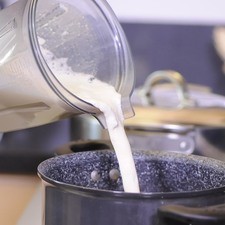 Licuar los granos de elote con la leche evaporada y el azúcar. Vaciar la mezcla molida en una olla.