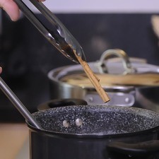 Agregar la rama de canela y poner a hervir a fuego medio durante 10 minutos con cuidado, mezclando con frecuencia para que no se derrame. Apagar el fuego, remover la rama de canela con una pinza.