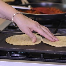 Para servir los tacos calentar las tortillas en el comal.