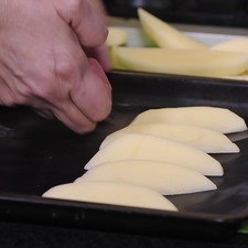 Colocar los gajos de papa en la charola para horno.