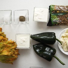 Ingredientes para receta 2 piezas de chile poblano 2 manojos de flor de calabaza 1/4 taza de yogur natural 1/4 taza de crema de leche de vaca 100 gramos de queso oaxaca pimienta negra molida al gusto sal al gusto 1 pieza de bolsa de plástico 200 gramos de pasta de pluma integral la moderna