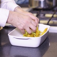 Añadir unas flores de calabaza en un refractario para horno.