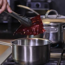 Poner a hervir las pieles de los chiles y el diente de ajo en una olla con un poco de agua durante 5 minutos. Dejar enfriar.