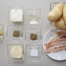 Ingredientes para receta 4 piezas de papa blanca 3 cucharadas de mantequilla 3 cucharadas de queso parmesano 3 cucharadas de crema de leche de vaca 1 cucharada de tomillo 2 rebanadas de tocino sal al gusto pimienta negra molida al gusto 1 cucharita de aceite vegetal comestible