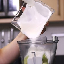 Agregar el yogur, diente de ajo, y un poquito de sal en el vaso de la licuadora y moler bien hasta obtener una mezcla homogénea.