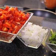 Picar finamente la cebolla y cilantro, cortar los pimientos en cubos pequeños descartando la parte blanca. Reservar
