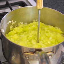 Agregar los trozos de chayote cocidos y machacar con el machacador de papa.