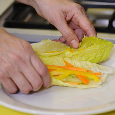 Para armar los tacos colocar una hoja de lechuga sobre la tabla de picar y añadir tiras de jícama, pepino, zanahoria y pimiento morrón.