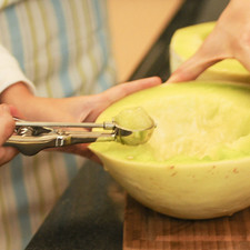Cortar el melón en bolitas pequeñas utilizando una cuchara pequeña.