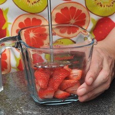 Cortar el pedúnculo de las fresas, descartarlo y partir la fruta en 4 partes. Colocar una parte de las fresas en un tazón y machacarlas bien con una cuchara, utilizar suficientes fresas para obtener 1 taza de jugo.