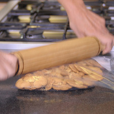 Precalentar el horno a 350º F Meter las galletas en una bolsa de plástico y moler con un palote. Poner en el molde y agregar la mantequilla derretida, aplastar sobre el molde y meter al horno de 10 a 15 minutos. En un tazón batir la crema hasta formar picos suaves, agregar el azúcar y la esencia de vainilla. Agregar el dulce de leche sobre las galletas y acomodar el plátano rebanado agregar la crema batida, adornar con chocolate rallado y meter al refrigerador hasta la hora de servir.