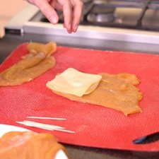 Colocar sobre la tabla para picar un trozo de milanesa, rebanada de queso.