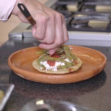 Añadir un poco de salsa roja, decorar con tiras de nopal.