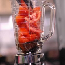 Colocar las pieles de los chiles junto con los jitomates cortados en cuartos en el vaso de a licuadora y moler hasta obtener una mezcla homogénea.