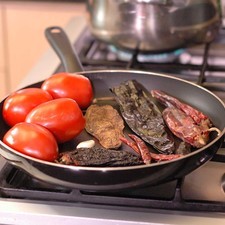 Asar los jitomates, los chiles y el diente de ajo sobre el comal, dando vueltas con una pinza hasta que se vean cocidos y la piel esté tostada. El ajo no debe quedar quemado porque amarga.