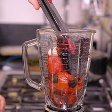 Colocar los jitomates asados, diente de ajo, cebolla y las pieles de los chiles en el vaso de la licuadora y moler hasta obtener una mezcla homogénea.