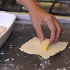 Poner un pedazo de manzana y enrollarlo con la masa Engrasar un molde cuadrado y acomodar las empanadas. En un tazón poner la mantequilla derretida, canela, azúcar y vainilla mezclar bien y poner sobre las empanadas. Vaciar el refresco de toronja entre las empanadas, no sobre ellas, y hornear de 30 a 35 minutos. Servir calientes y se puede agregar una bola de nieve de vainilla