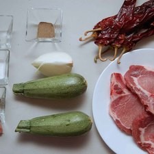 Ingredientes para receta 4 piezas de chuleta de cerdo 1/4 pieza de cebolla blanca 6 piezas de chile guajillo 2 piezas de calabacita italiana 1 diente de ajo 1 pizca de orégano 1 pieza de clavo de olor pimienta negra molida al gusto sal al gusto