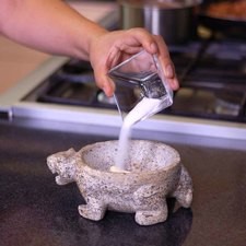 Machacar los dientes de ajo y un poquito de sal en un molcajete o mortero.