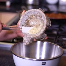 Añadir el ajo molido en un tazón y añadir el aceite de oliva, revolver bien con el batidor de globo.