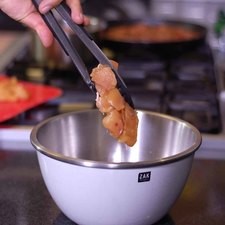 Añadir los trozos de pollo al tazón con la mezcla de aceite y dejar marinar durante 10 minutos.