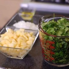 Picar finamente la cebolla y la papa. Cortar el queso en cubos a tamaño bocado. Retirar las hojas de cilantro del tallo y reservar.