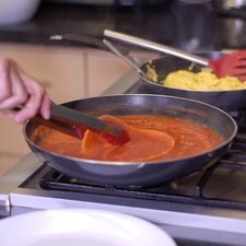 Pasar cada tortilla rápidamente por la salsa caliente para que se suavice.