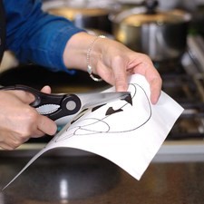 Colocar la hoja sobre el queso. Espolvorear las galletas molidas sobre toda la superficie con la ayuda de un colador.