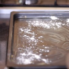 Engrasar la charola con un poco de mantequilla y espolvorear un poco de harina.