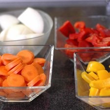 Cortar en trozos grandes la cebolla, pimiento morrón rojo y amarillo descartando la parte blanca, el brócoli en floretes, la zanahoria y diente de ajo en rodajas. Rs 1477519361
