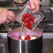 Agrega la crema, el queso desmoronado y las fresas congeladas.